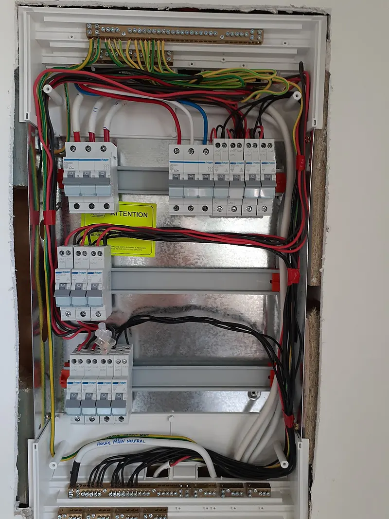 Finished switchboard with new breakers and safety switches in a white enclosure